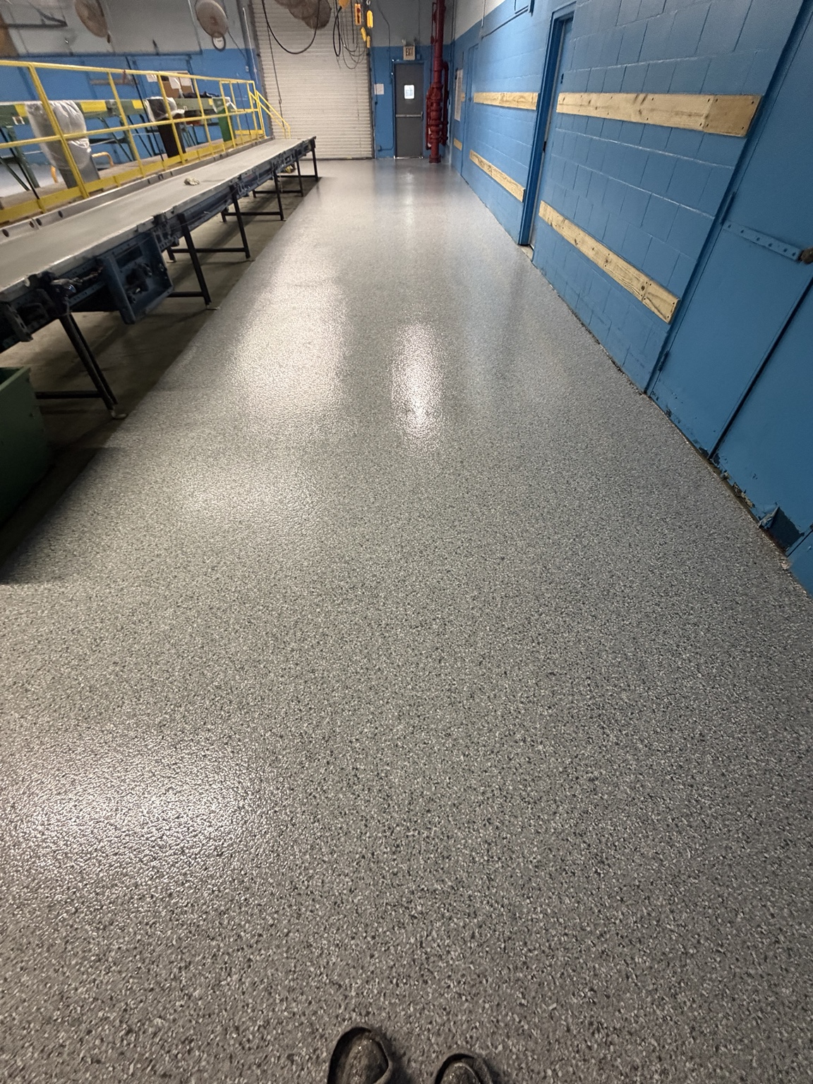 Finished decorative flake coating beside a commercial conveyor line