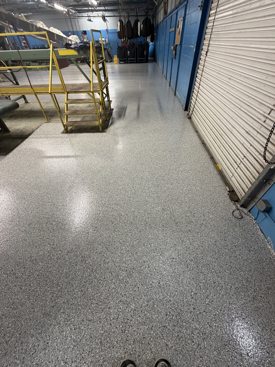 Gray flake floor coating near an industrial rollup door