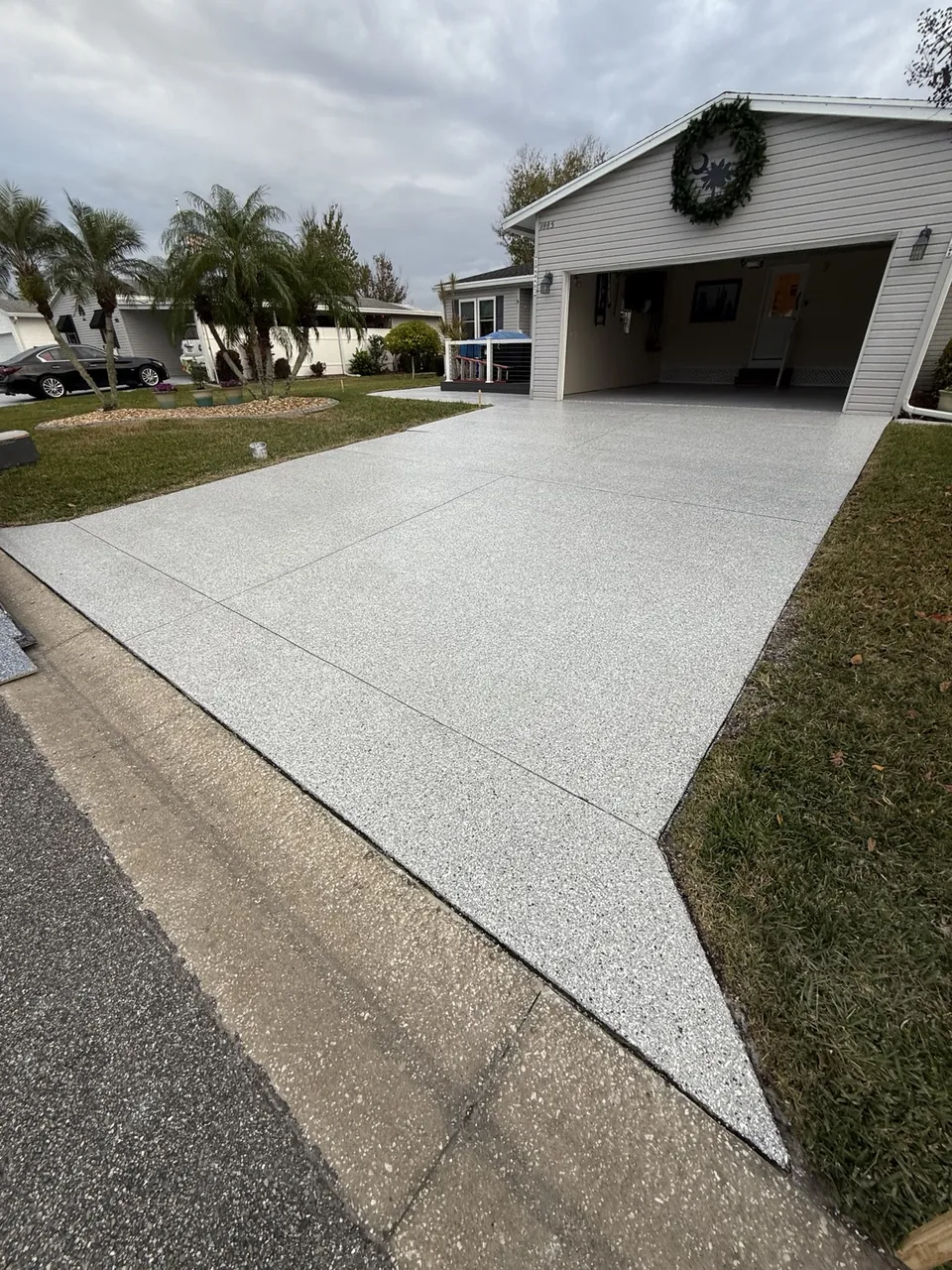 Freshly coated white and gray driveway with a garage entrance