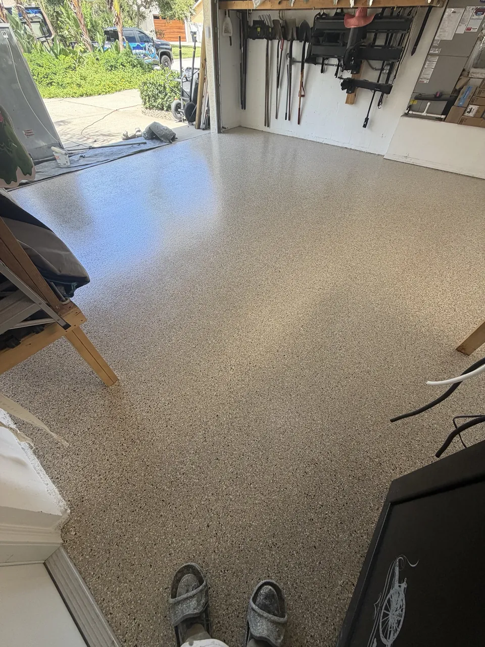 Tan flake garage floor coating extending toward the driveway