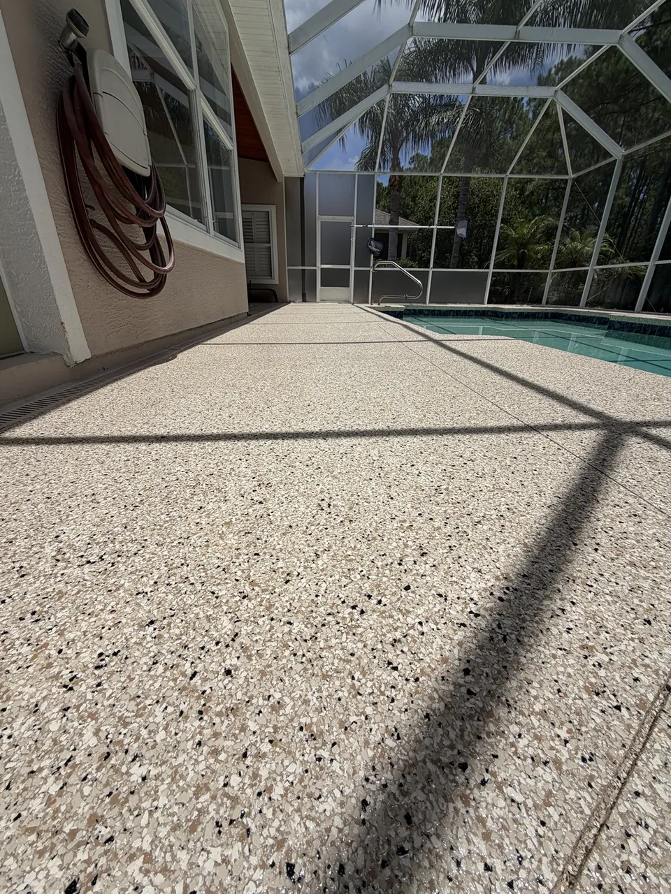 Close view of tan flake pool deck texture beside the pool